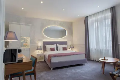 a bedroom with a bed and a desk and a television at Public House Hotel in Belgrade
