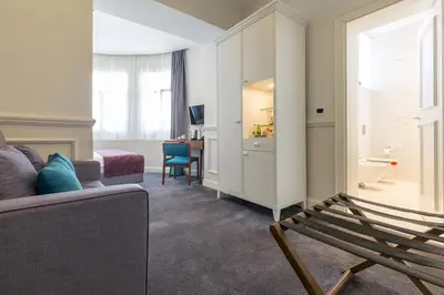a room with a couch and a chair and a desk at Public House Hotel in Belgrade