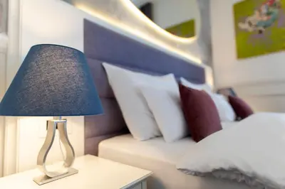 a lamp sitting on a table next to a bed at Public House Hotel in Belgrade