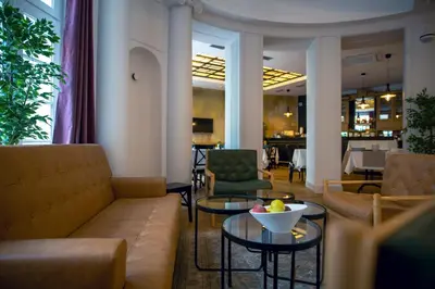 a lobby with couches and tables and a dining room at Public House Hotel in Belgrade