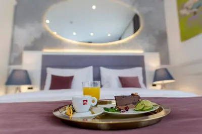 a tray with a plate of food and a cup of orange juice at Public House Hotel in Belgrade