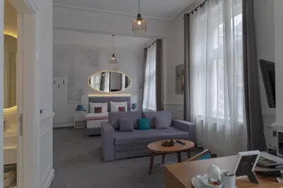 a living room with a blue couch and a bed at Public House Hotel in Belgrade