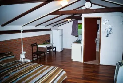 a bedroom with a bed and a table and a kitchen at Julijana in Belgrade
