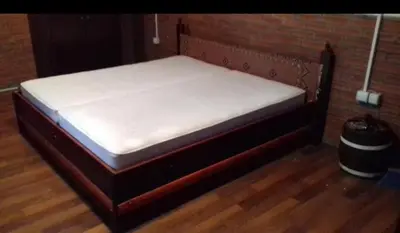 a bed in a room with a wooden floor at Julijana in Belgrade