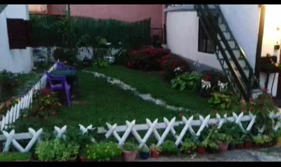 a garden with a white fence and some flowers at Julijana in Belgrade