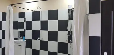 a bathroom with a black and white checkered wall at DND-X in Pančevo