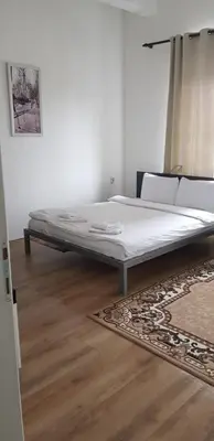 a large bed in a room with a rug at DND-X in Pančevo