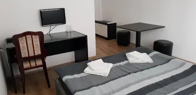 a room with a bed and a desk and a chair at DND-X in Pančevo