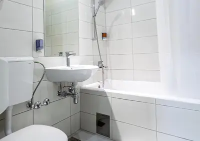 a white bathroom with a sink and a toilet at Booking En Suite in Belgrade