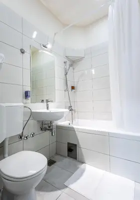 a white bathroom with a toilet and a sink at Booking En Suite in Belgrade