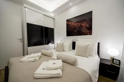 a bedroom with a large white bed with towels on it at CENTAR Lux in Arandjelovac