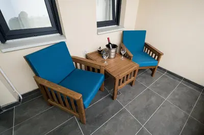two chairs and a wooden table with blue chairs at CENTAR Lux in Arandjelovac