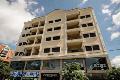 a tall white apartment building with windows at CENTAR Lux in Arandjelovac