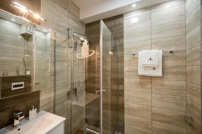 a bathroom with a glass shower and a sink at CENTAR Lux in Arandjelovac