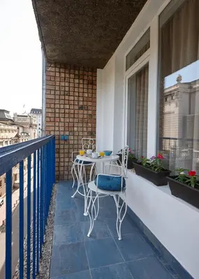 a patio with a table and chairs on a balcony at Take 5 in Belgrade