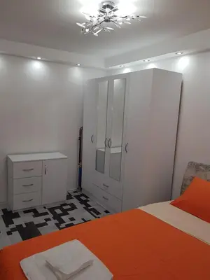 a bedroom with a bed and a cabinet and a desk at Rabit delux II in Belgrade
