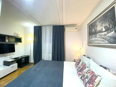 a bedroom with a large bed and a television at Villa Forever in Belgrade