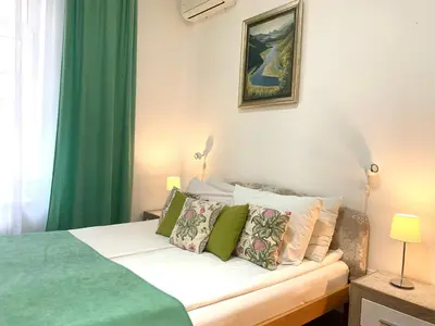 a bedroom with a bed with green and white pillows at Villa Forever in Belgrade