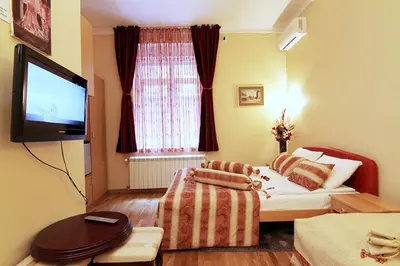 a hotel room with a bed and a flat screen tv at Villa Forever in Belgrade