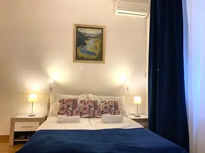 a bedroom with a large bed with a blue blanket at Villa Forever in Belgrade
