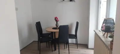 a dining room table with black chairs and a vase on it at Cute little apartment in Belgrade