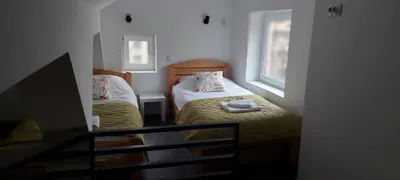 a small room with two beds and two windows at Cute little apartment in Belgrade