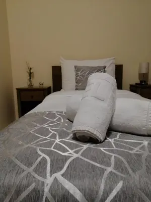 a bed with a blanket and pillows on it at Apartmani CENTAR- Smederevo in Smederevo