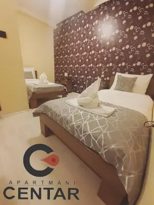 a room with two beds and a sign on the wall at Apartmani CENTAR- Smederevo in Smederevo