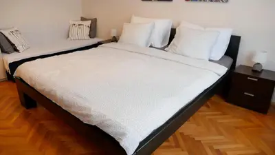 a large bed with white sheets and pillows on it at Apartman Mia in Belgrade