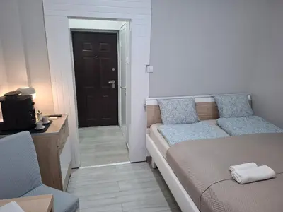 a bedroom with a bed and a door to a hallway at SnowWhite New Apartment in Belgrade