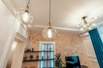 a living room with three lights and a brick wall at Miha Luxury Apartment in Belgrade