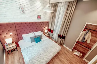 a bedroom with a white bed with a pink headboard at Miha Luxury Apartment in Belgrade