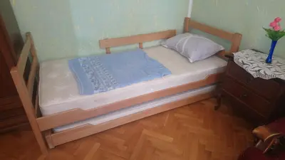 a small bed with a wooden frame and a dresser at Garden in Belgrade