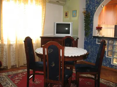 a dining room with a table and a tv at Garden in Belgrade