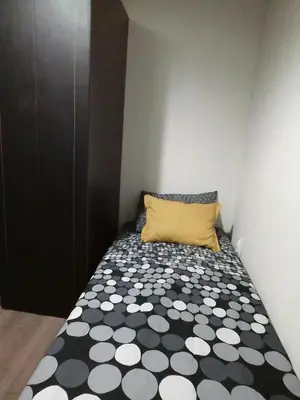 a small bedroom with a black and white bed with a yellow pillow at City centre penthouse in Belgrade
