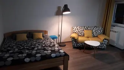 a bedroom with a bed and a chair and a lamp at City centre penthouse in Belgrade