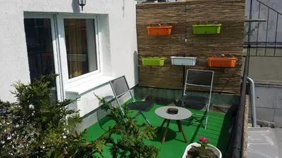 a balcony with a table and chairs and a window at City centre penthouse in Belgrade