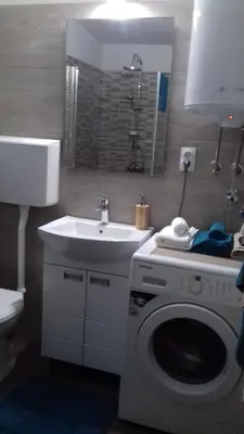 a bathroom with a washing machine and a sink at City centre penthouse in Belgrade