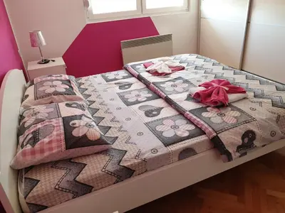 a bed with a hello kitty quilt on it at Apartment Centar Deluxe in Smederevo