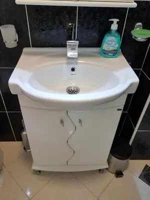 a white sink with a bottle of soap on top at Apartment Centar Deluxe in Smederevo
