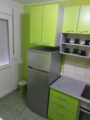 a kitchen with green cabinets and a stainless steel refrigerator at Apartment Centar Deluxe in Smederevo
