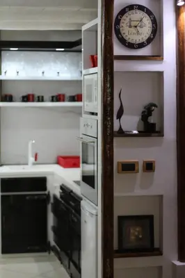 a kitchen with a clock on the wall and a stove at Apartman Rustik in Belgrade