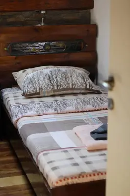 a bed with a wooden headboard and a pillow at Apartman Rustik in Belgrade
