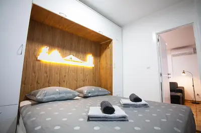 a bedroom with a large bed with towels on it at White Lux apartment in Belgrade