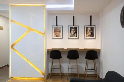 a mirror in a room with a table and stools at White Lux apartment in Belgrade