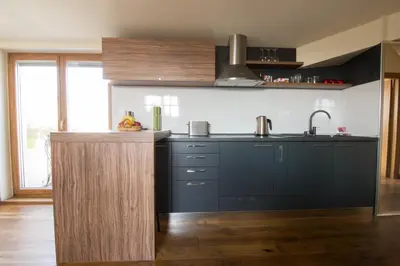 a kitchen with black cabinets and a counter top at St. Sava Temple/Slavija square in Belgrade