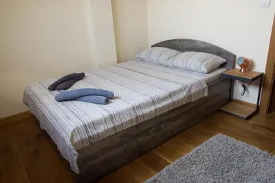a bed with two pillows and a blue shirt on it at St. Sava Temple/Slavija square in Belgrade