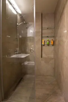 a shower with a glass door and a sink at St. Sava Temple/Slavija square in Belgrade
