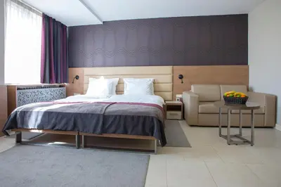 a bedroom with a bed and a couch and a chair at Hotel Srbija Garden-FREE PARKING-upon availability in Belgrade