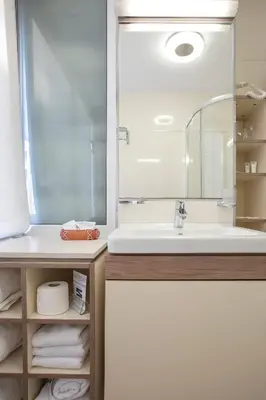 a bathroom with a sink and a mirror and towels at Hotel Srbija Garden-FREE PARKING-upon availability in Belgrade